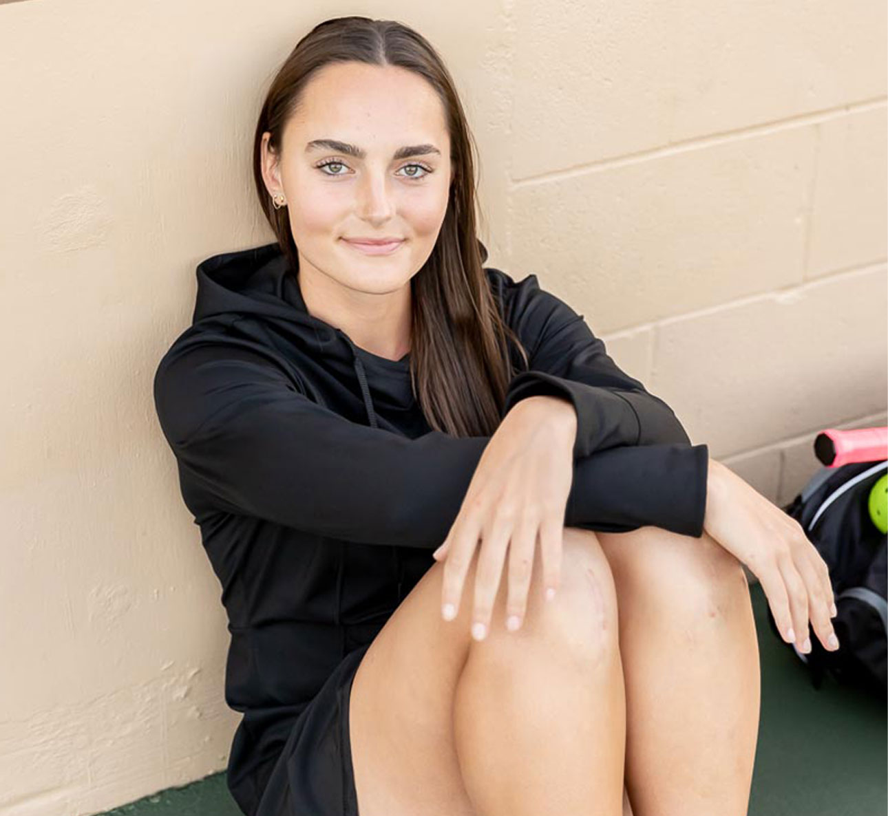 women sitting at a pickleball court